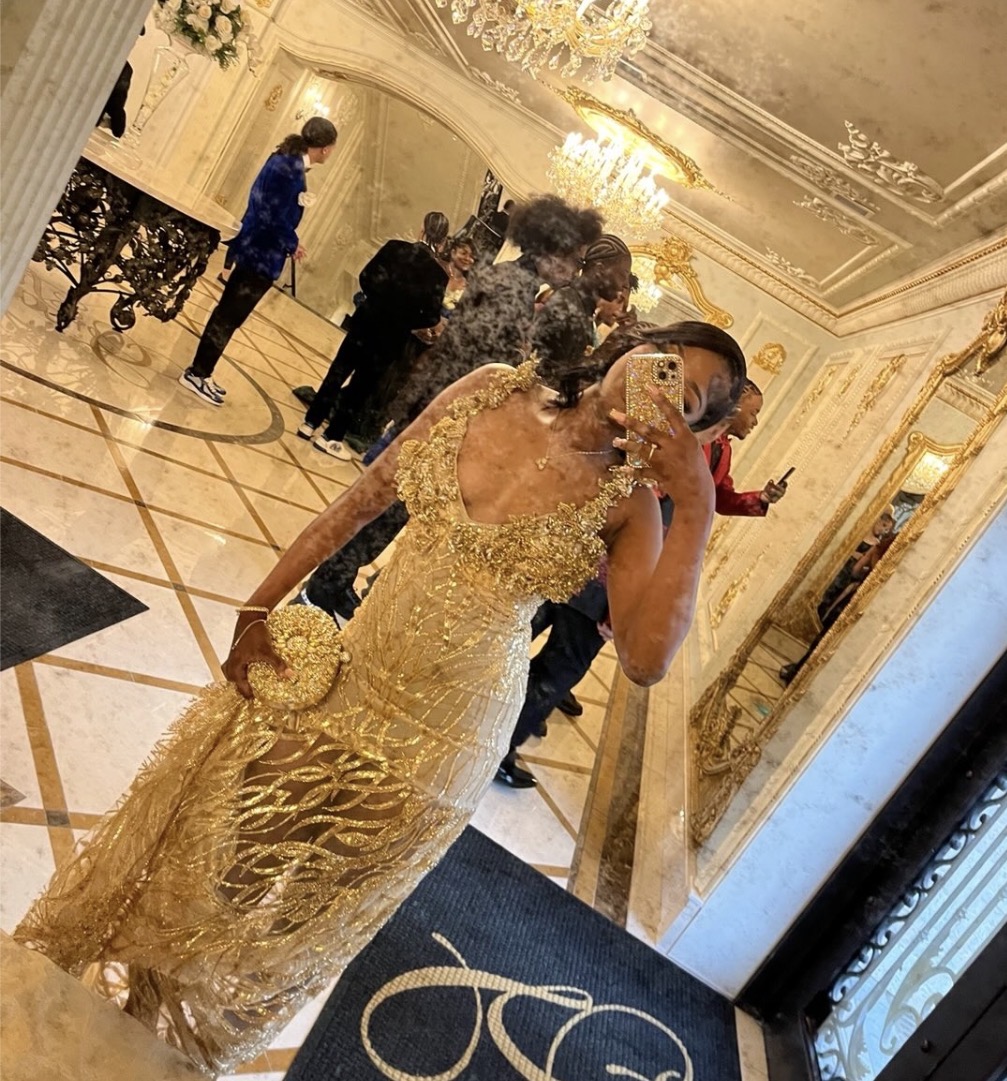 Gold beaded couture evening gown in a chandelier-lit ballroom